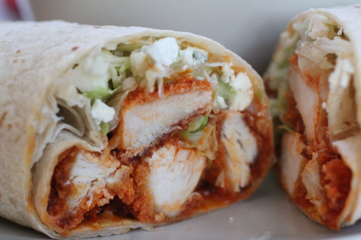 Crispy chicken wraps filled with shredded meat, lettuce, cheese, and white crema sauce.